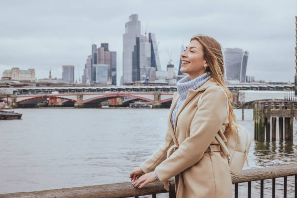 istock Young cheerful light haired woman smiling while day dreaming and posing near Thames river in down town City of London, England - creative stock photo 2060317165
