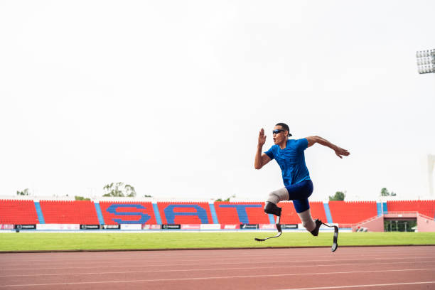 istock Asian para-athletes disabled with prosthetic blades running at stadium. Attractive amputee male runner exercise and practicing workout for Paralympics competition regardless of physical limitations 2060317176