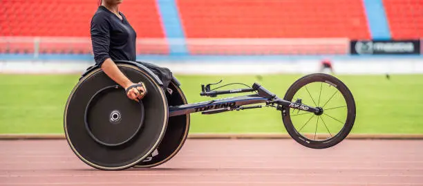Asian young man para-athletes disabled practice handcycling in stadium. Attractive amputee male runner exercise and practicing workout for Paralympics competition regardless of physical limitations.