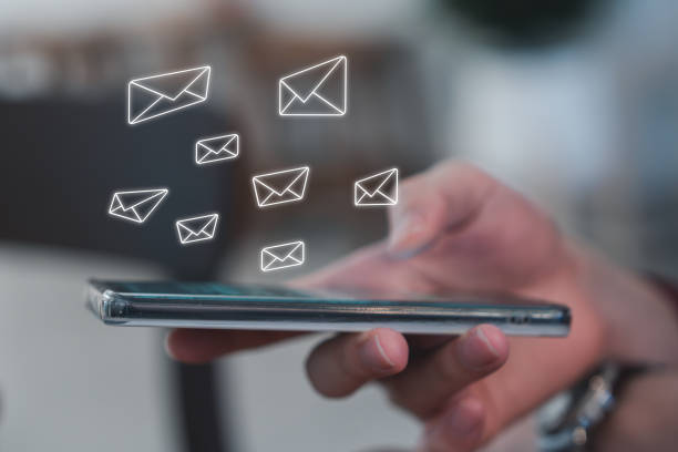 istock E-mail spam or email marketing concept. Hand using mobile smartphone and receive new multiple email. 2060352121