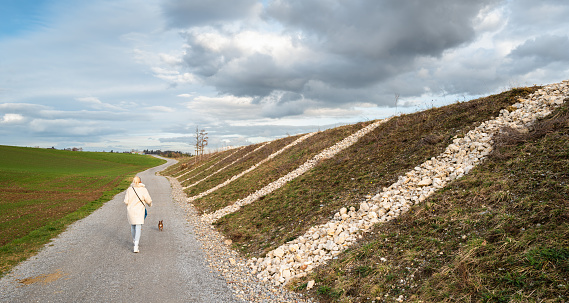 Walkway along the highway embankment between Regensdorf and Affoltern, Switzerland. Woman with a dog.