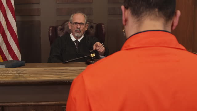 Judge talking to inmate over the shoulder zoom in during court room trial