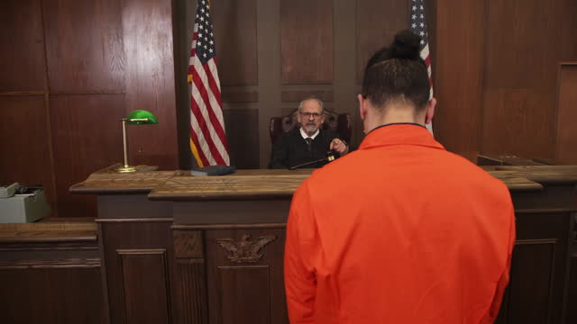 Judge pointing at defendent in orange jumpsuit