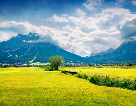 Green meadow on the Golf club Zugspitze, Lermoos village loccation. Colorful summer morning in  Austrian Alps, Reutte district, state of Tyrol, Austria, Europe. Artistic style post processed photo.