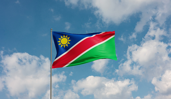 Flag Namibia against cloudy sky. Country, nation, union, banner, government, Namibian culture, politics. 3D illustration