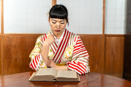 A woman in Japanese clothes reading a book