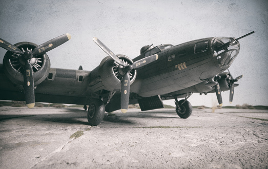 A scale model of the iconic B-17 Flying Fortress sitting on a scale model airfield. The B-17 was an American four-engined heavy bomber aircraft developed in the 1930s for the United States Army Air Corps and made by Boeing.