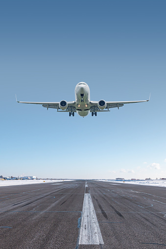 White passenger jetliner take off airport runway at winter