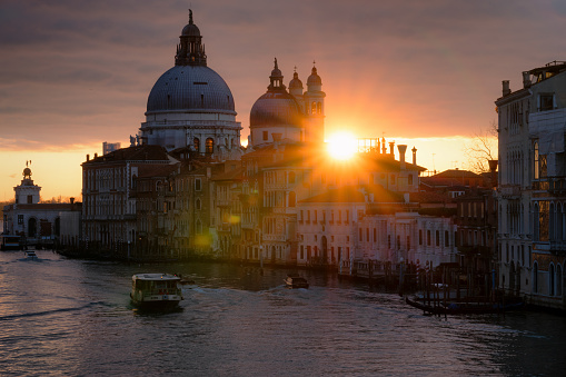 Looking out across the magnificent Grand Canal in Venice at dawn, with the majestically-domed Santa Maria della Salute Basilica in the background. Light trails from various boats can be seen making their way up the waterway.
