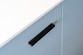 Closeup on black handle on cabinet door at modern kitchen