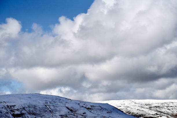 Welsh mountain winter landscape. Snow on the top of the mountains above Storey Arms in the Brecon Beacons.  Icy conditions but the sun is shining and has melted the snow of the foothills.