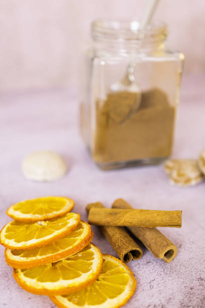 Dry ginger bread spice in a jar with sliced orange and cinnamon stick.