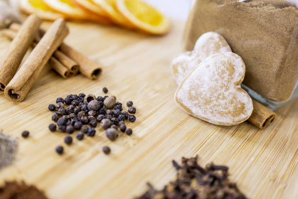 Dry ginger bread ingredients: cinnamon, ginger, black pepper, nutmeg, cloves and orange slices on wooden board. Spices for all tastes.