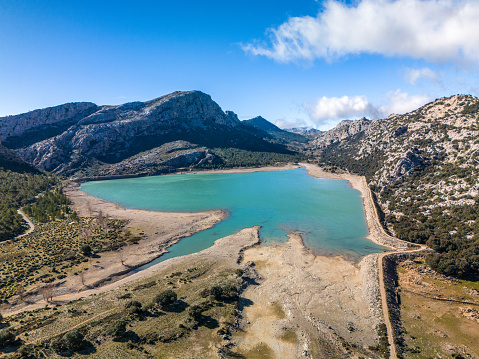 Capture the breathtaking beauty of Cuber Lake in Mallorca with this stunning aerial drone view. Nestled in the heart of the Serra de Tramuntana, the Cuber reservoir is a testament to the island's rich natural wealth. The high rainfall and variable relief of the area make it one of the most picturesque landscapes in Mallorca.