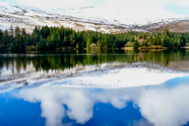 Welsh mountain winter landscape. Snow on the top of the mountains above Storey Arms in the Brecon Beacons.  Icy conditions but the sun is shining and has melted the snow of the foothills.