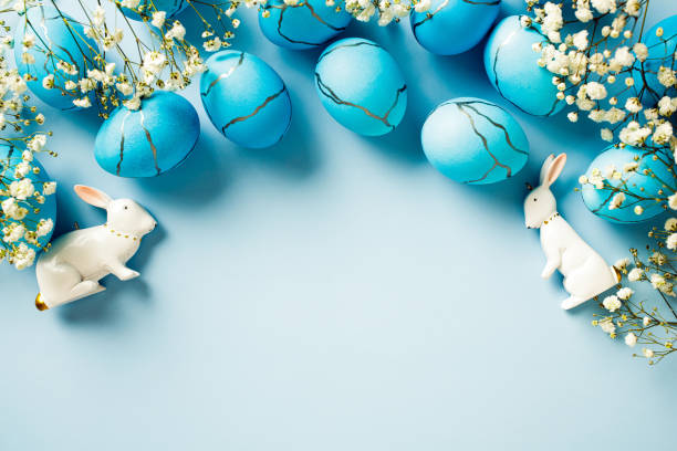 istock Blue Easter eggs, flowers, rabbits on a blue background. Flat lay, top view, copy space. 2060462291