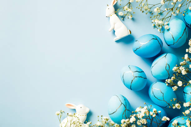 istock Cute Easter eggs, flowers, decorative rabbits on a blue background. Flat lay, top view, copy space. Happy Easter card design. 2060463360