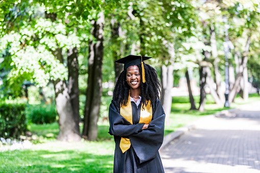 Portrait of Black Female University Graduate wearing black gown and cap