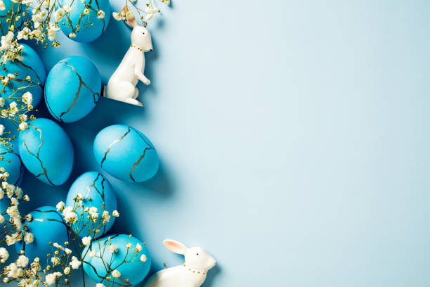 istock Painted Easter eggs, delicate flowers, bunny on a blue background. Flat lay, top view, copy space. 2060474574