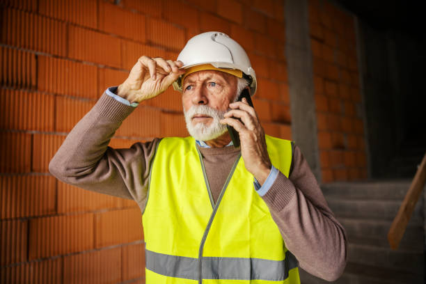 istock A worried senior contractor is having a phone call while standing at construction site. 2060481962
