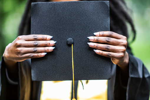 Portrait of Black Female University Graduate wearing black gown and cap