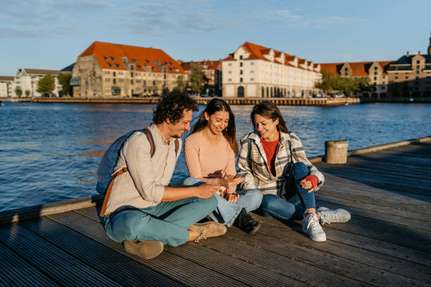 istock Three Young Friends Using Smart Phone On The Dock In Copenhagen In Denmark 2060500785