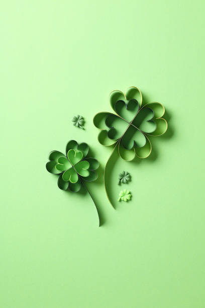 istock St Patricks day four leaf clover paper cut on green background. 2060500919