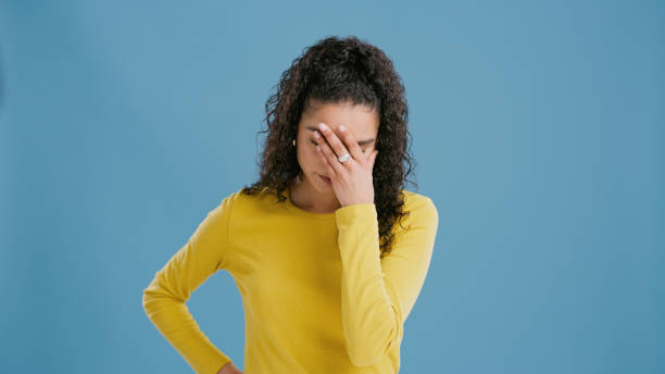 istock Woman, studio and hand on face for headache with mistake, stress and burnout with problem on blue background. Thinking, tired and person with gesture for sad, anxiety and fatigue with pressure 2060505692