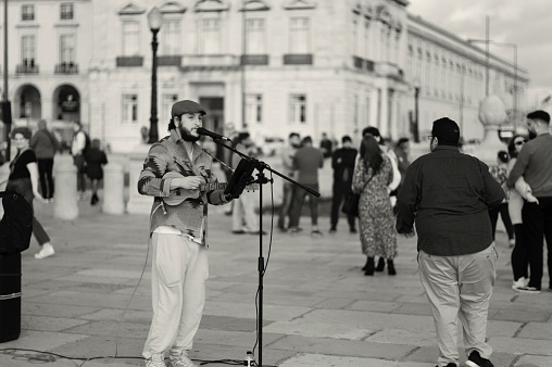 Lisbon, Portugal - November 11, 2023: A street musician plays a ukelele and sing at the Praça do Comércio square in Lisbon downtown.