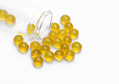 Vial full of yellow transparent small capsules, cod liver oil