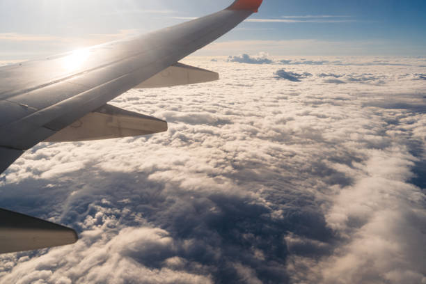 View from the airplane window mid air above clouds.