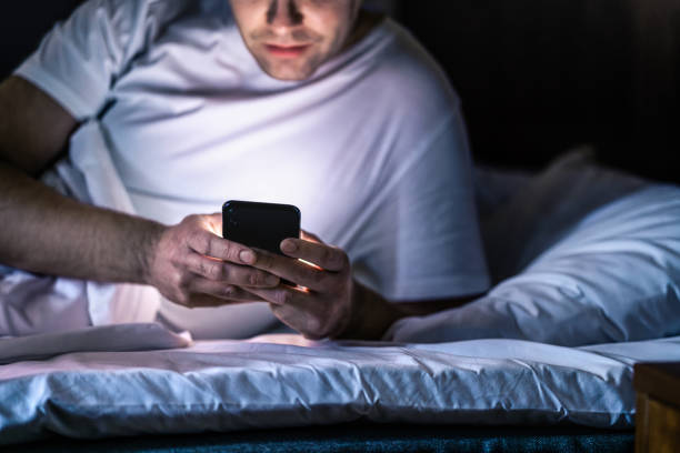 istock Man in bed with phone at night. Texting with smartphone before sleeping. Guy holding cellphone in hand. Dark home bedroom. Infidelity, cheating or working late online concept. 2060559160