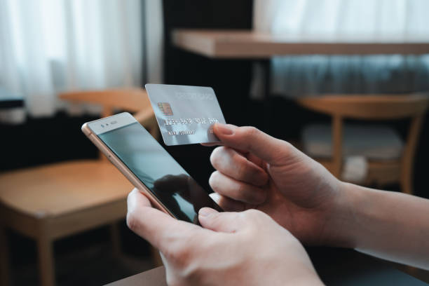 istock Hand holding credit card and smartphone doing online banking transaction. E-commerce, Online shopping, online payment, Mobile banking and online transaction payment concept. 2060559680