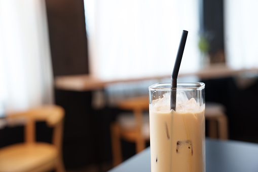 Iced coffee latte in tall glass at cafe. Enjoy beverage, Freshness and relaxation.