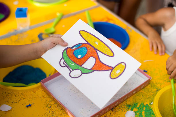 istock A child draws with colored sand picture. Cartoon characters. 2060562827