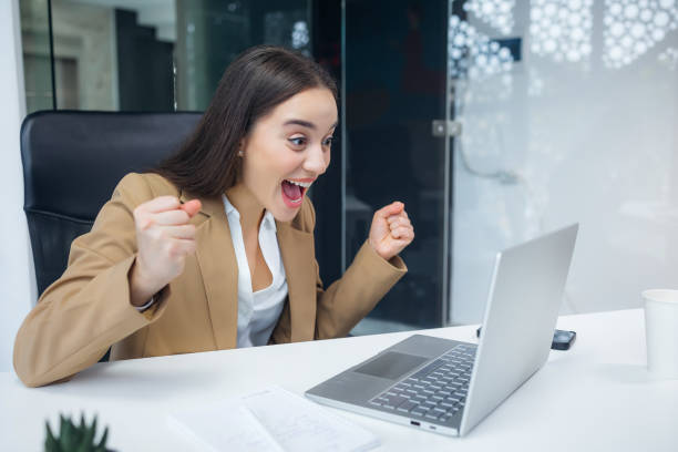 istock Excited cheerful young woman using laptop computer at office getting good news, feeling joy 2060566513