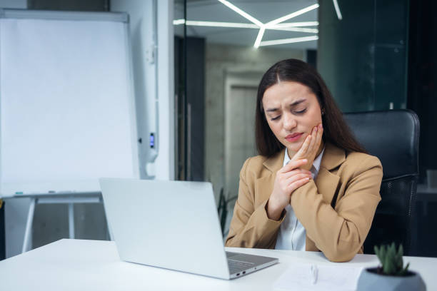 istock Dark haired caucasian lady feeling severe toothache during working process on laptop at office. 2060566546