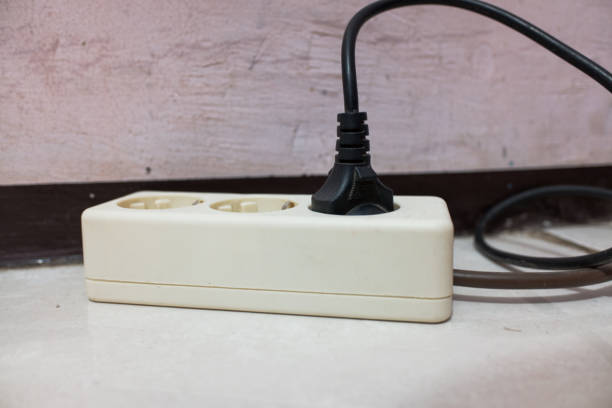 白い3穴ソケットが差し込まれています - extension cord push button cable electric plug ストックフォトと画像