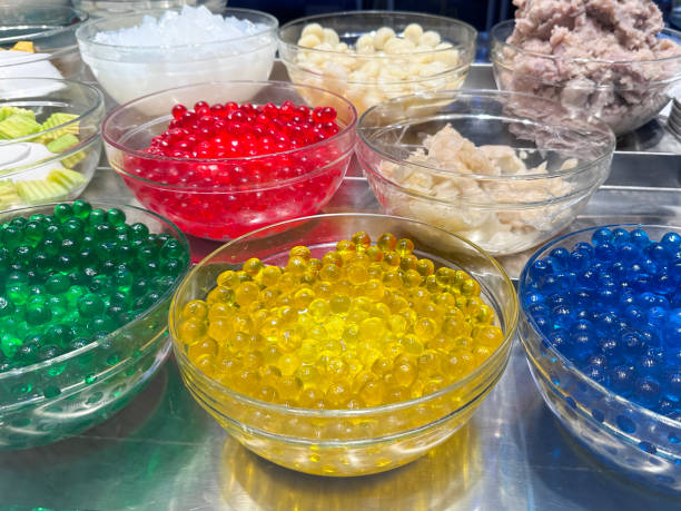 close up of fork full of colorful plastic beads, microplastics concept, on blue background