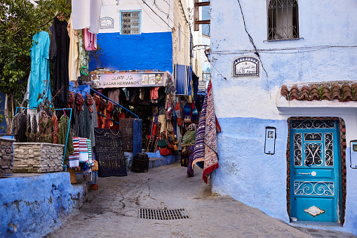 Narrow shopping street in blue city of Chefchaouen, Morocco, North Africa.