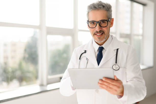 istock Experienced confident senior doctor with grey hair using tablet 2060618673