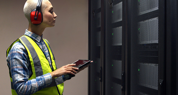 IT engineer, working and tablet in server room for cyber security and troubleshooting a problem in network. Woman, technical support and technology for computer programming and analytics for coding