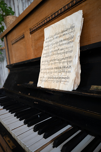 black old piano in cracks with notes.