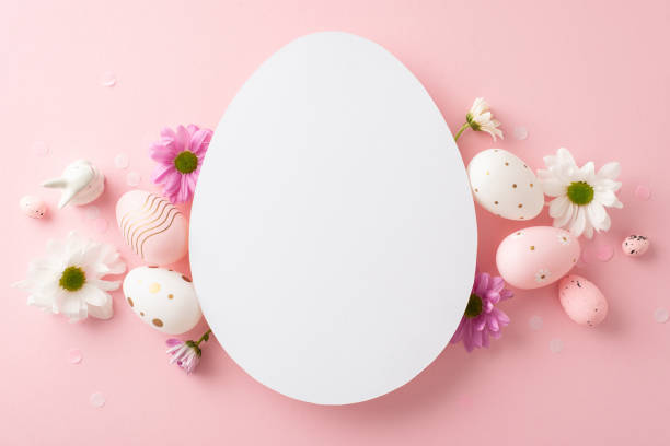 istock Fashionable Easter display image. Top view angle of eggs, vivid chrysanthemums, ceramic bunny, and confetti on a pastel pink ground with blank egg-shaped cutout for wording or promotions 2060685587