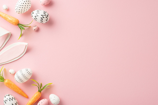 Easter setting idea: Top view photo of understated dyed eggs, cute rabbit ears, and carrots as Easter Bunny rewards on a blush background, providing a vacant space for your text