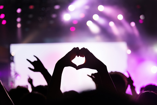 Hands making heart shape at music festival