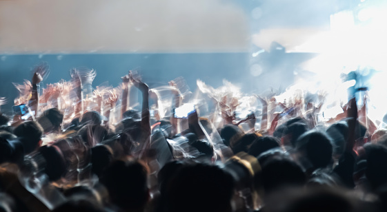 Confetti. A crowd of people in silhouette raises their hands, dancing on dancefloor on neon light background. Night life, club, music, dance, motion, youth. Bright colors and moving girls and boys.