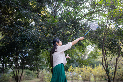 Woman playing badminton in public park