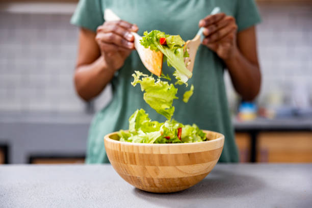 istock Close-up on a woman tossing a salad while cooking at home 2060736832