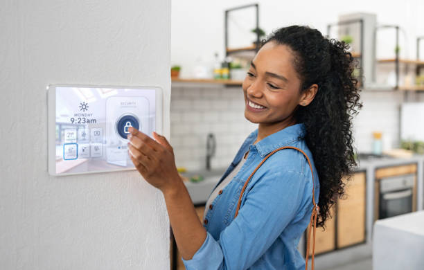 Woman locking her house using a smart security system African American woman locking her house using a smart security system home automation stock pictures, royalty-free photos & images